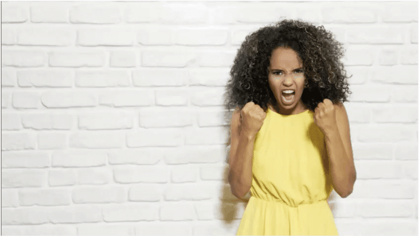 girl holding her fists clenched shouting in a stressed manner