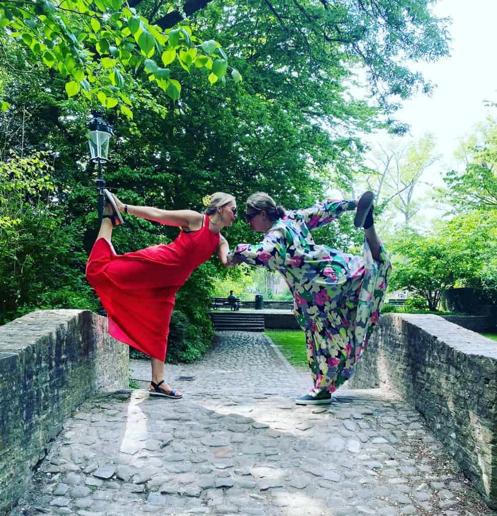 tabitha wright in dancers pose with another woman mirroring the pose outside on a cobbled bridge